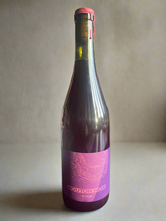 A bottle of Mouton Noir Rouge wine, featuring a striking purple label with elegant text. The wine is showcased on a neutral background, highlighting its premium quality.