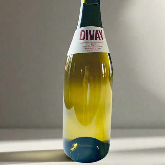 A close-up image of a bottle of Divay Blanc 2021, a biodynamic Grenache Blanc white wine with a minimalist label, placed on a light surface. Perfect for showcasing the wine's premium quality and natural elegance.